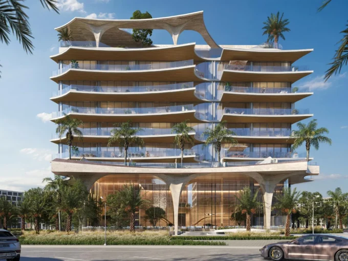 A futuristic Ola Residences building with wavy concrete elements and large balconies is seen from the street.